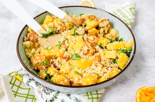 Grote kom met een salade van couscous, mango, scampi en noten erin.