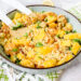 Grote kom met een salade van couscous, mango, scampi en noten erin.