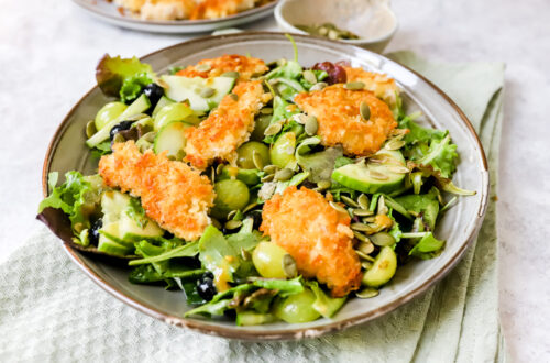 diep bord met een salade van druiven en bosbessen met daarop goudbruin gebakken krokante kip.