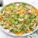 Een grote schotel met een fris ogende salade van rucola, makreel en sinaasappel. Afgewerkt met geroosterde sesamzaadjes, tuinkers en een vinaigrette van mosterd, sinaasappel en olijfolie.