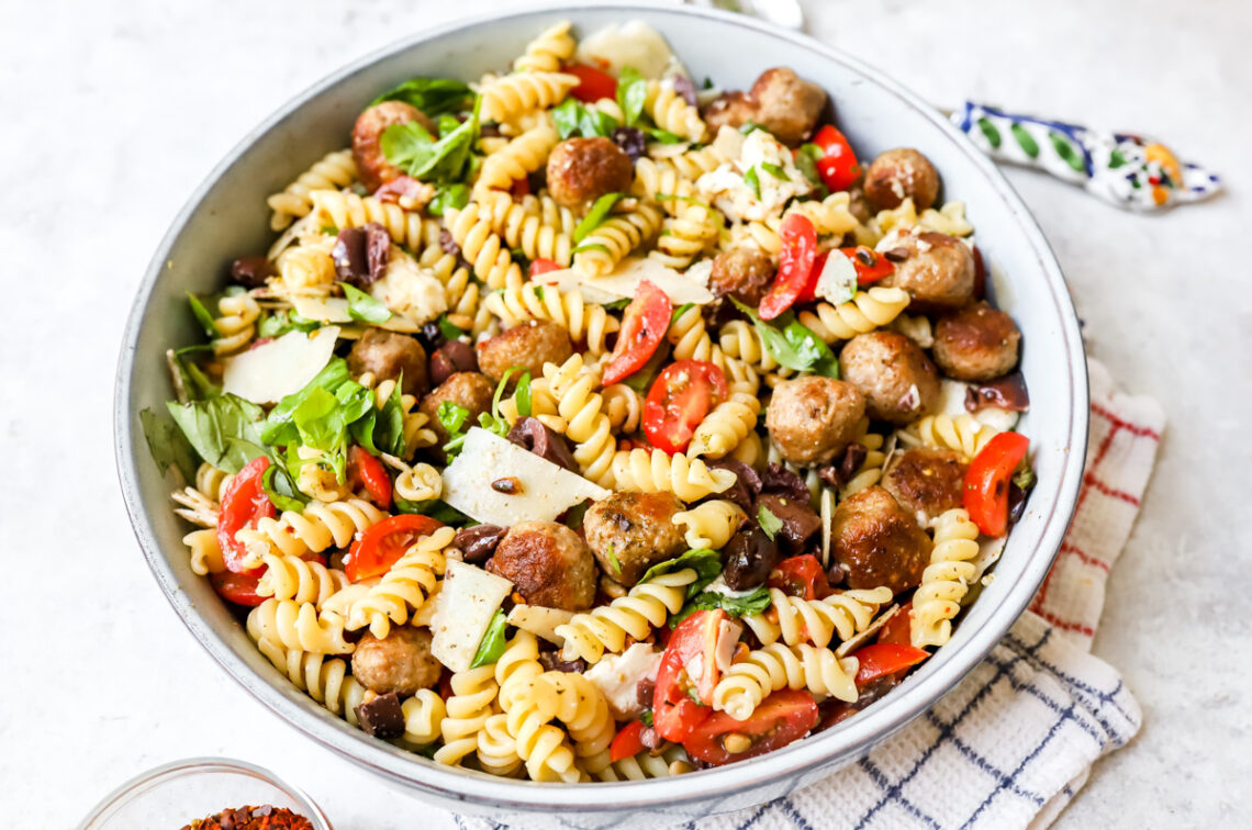 grote kom pastasalade met mini gehaktballetjes, mozzarella, parmezaan, tomaatjes, pijnboompitten en heel veel basilicum.